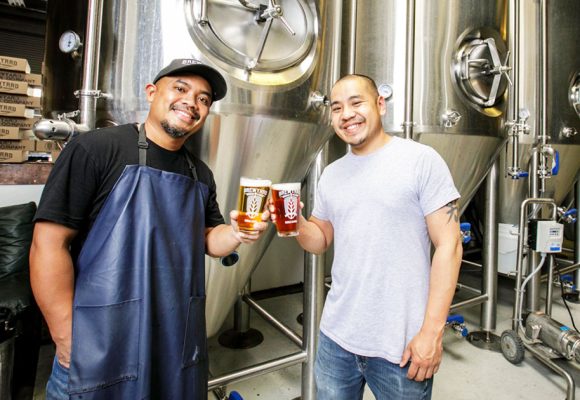 brewers cheersing in beer production area