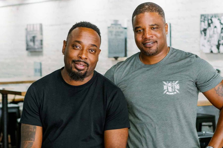 brewery owners posing together inside taproom