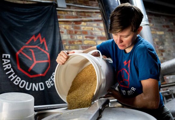 woman pouring grain in brewhouse