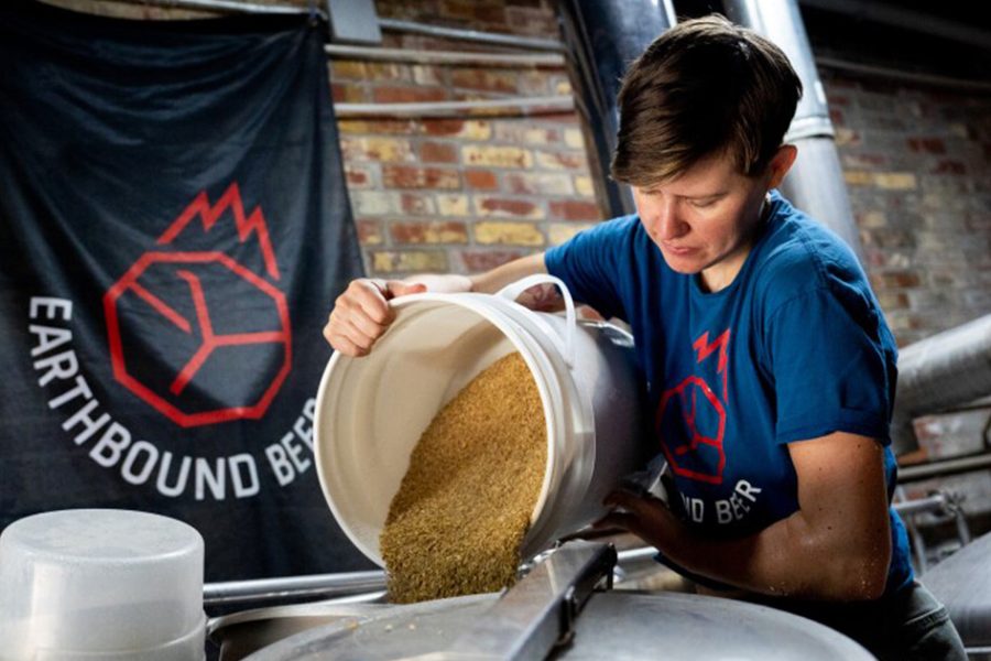 woman pouring grain in brewhouse